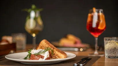 Gericht mit Toastbrot und Getränken auf einem gedeckten Holztisch