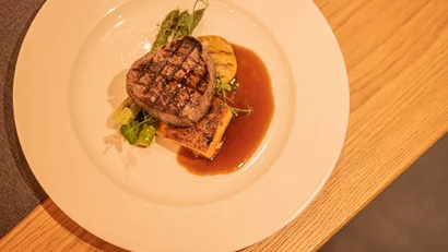 Gegrilltes Steak mit Gemüse und Sauce auf weißem Teller