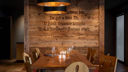 Gemütlicher Essbereich mit Holztisch, Stühlen und schwarzen Deckenlampen