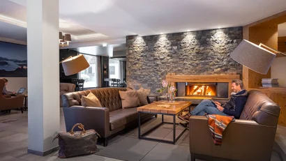 Gemütlicher Sitzbereich mit Kamin, zwei Ledersofas und Holztisch