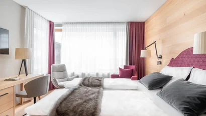 Helles modernes Hotelzimmer mit Doppelbett, Schreibtisch und Sitzbereich