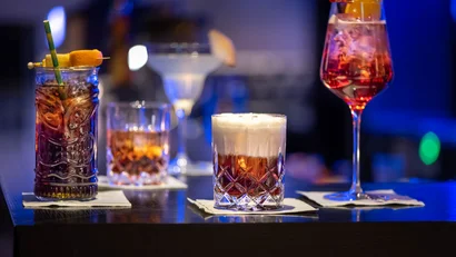 Verschiedene bunte Cocktails auf einer Bar mit dunklem Hintergrund