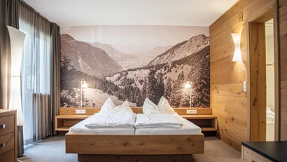 Modernes Schlafzimmer mit Holzdetails und Berglandschaftswandfoto