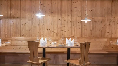 Rustikaler Holzesstisch mit Stühlen und dekorierten Gläsern in Restaurant