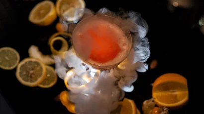 Cocktail mit Rauch und Zitronenscheiben auf dunklem Hintergrund