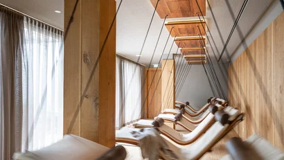 Mehrere schwebende Liegestühle in einem modernen, hellen Raum mit Holzverkleidung