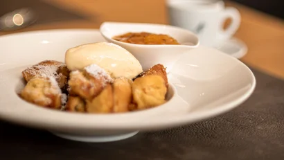 Kaiserschmarrn mit Eis und Apfelmus auf weißem Teller